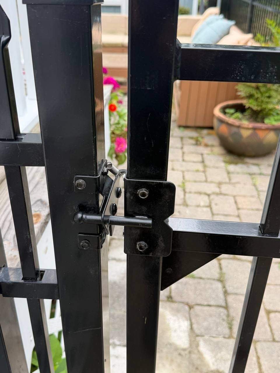Black aluminum ornamental fence and matching gate set in concrete along a graded yard in Chattanooga