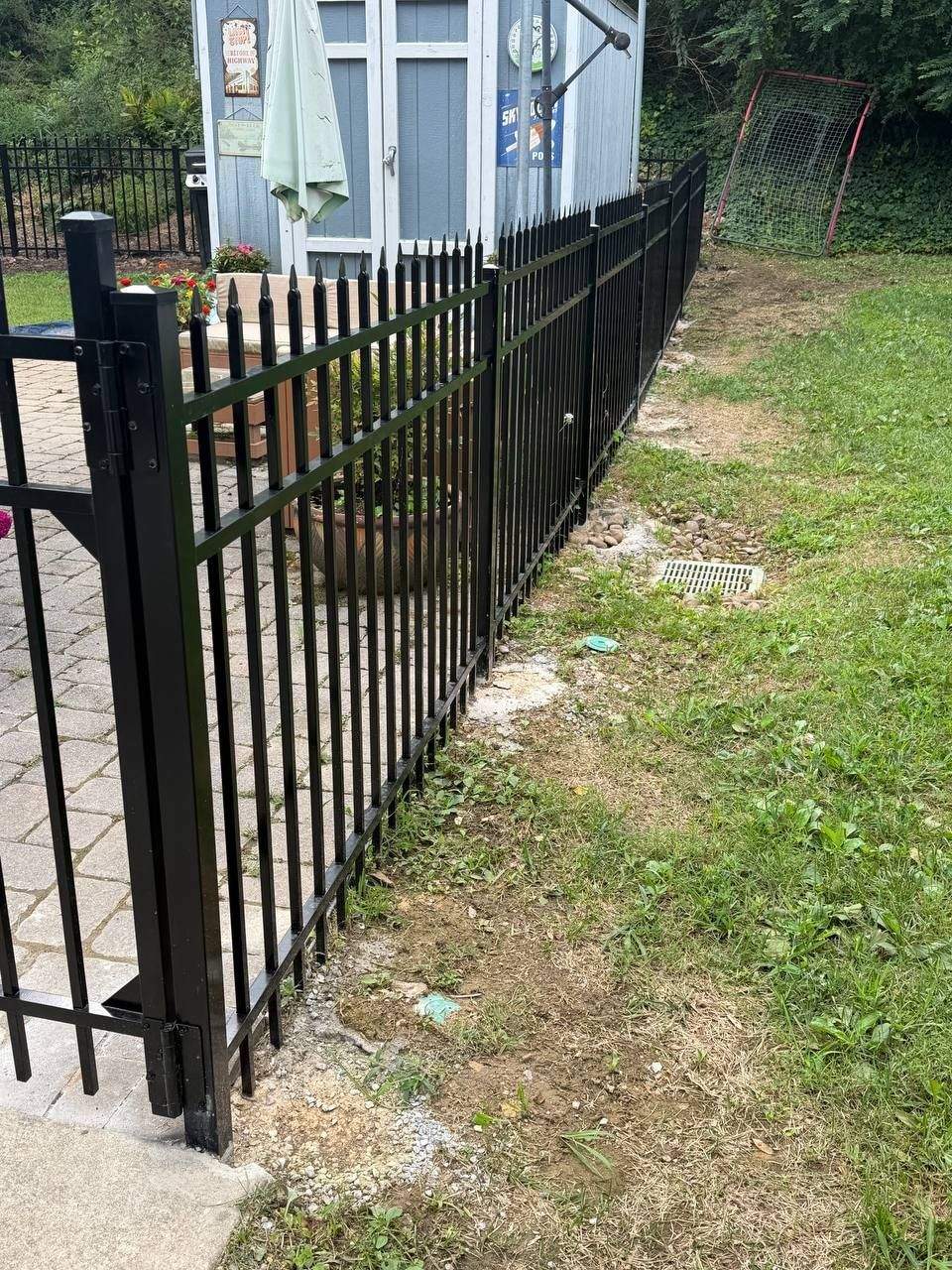 Aluminum picket fence panels set in concrete along a Chattanooga property line