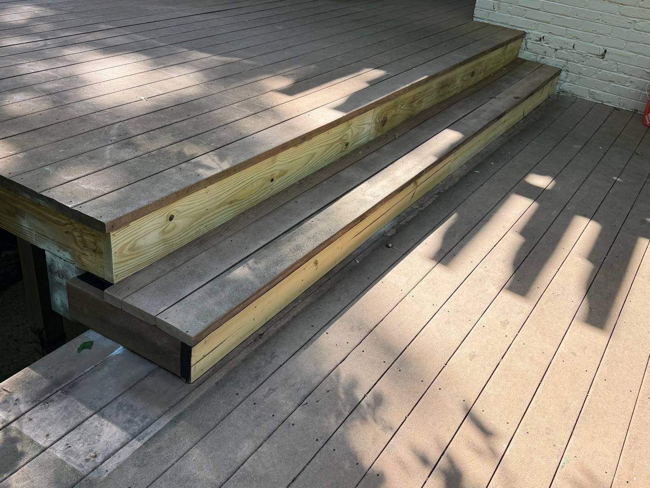 Newly rebuilt pressure-treated deck stairs with new stringers and framing, replacing rotted structural wood in Chattanooga